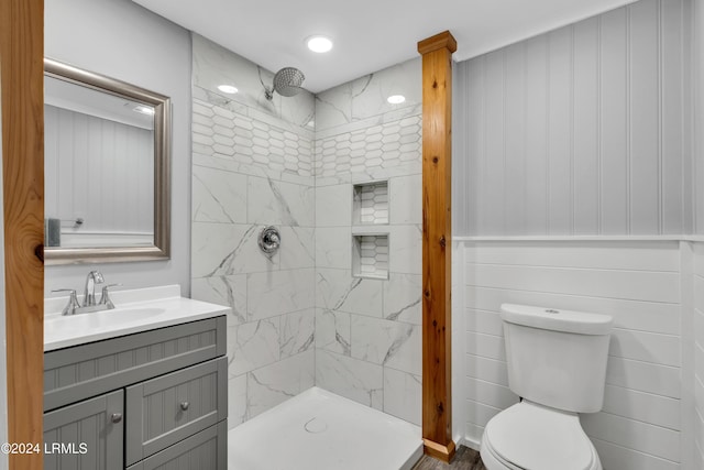 bathroom with vanity, toilet, and tiled shower