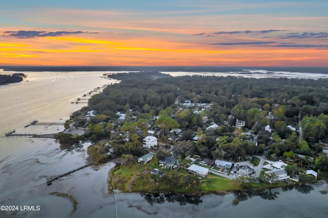 aerial view at dusk featuring a water view