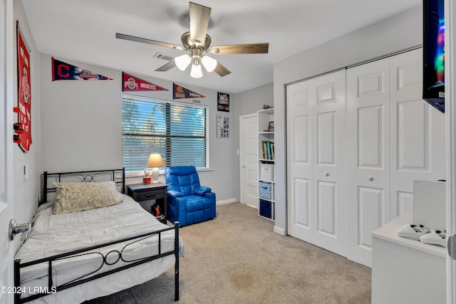 bedroom featuring ceiling fan, a closet, and light carpet