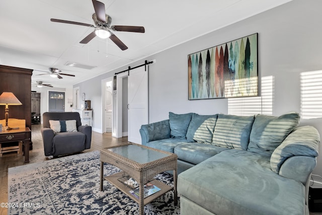 living room featuring hardwood / wood-style flooring, a barn door, and ceiling fan