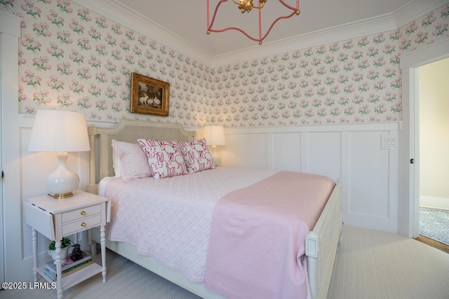 carpeted bedroom featuring a chandelier, wainscoting, crown molding, and wallpapered walls