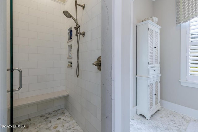 bathroom featuring a stall shower and baseboards