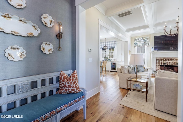 living room with beverage cooler, coffered ceiling, wood finished floors, visible vents, and wallpapered walls