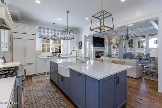 kitchen featuring blue cabinetry, plenty of natural light, crown molding, and built in fridge