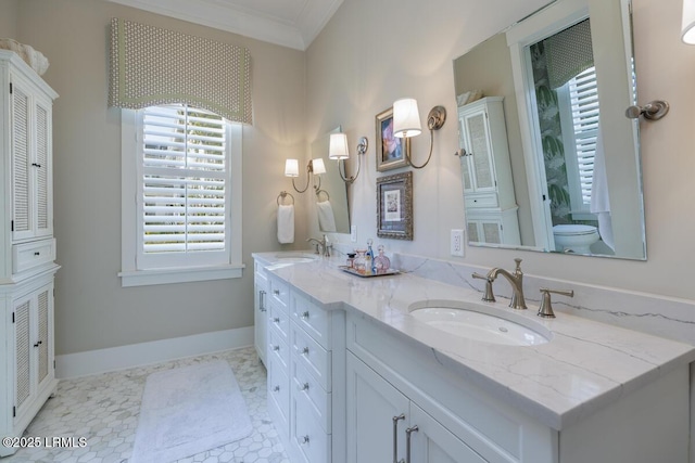 full bathroom with ornamental molding, a sink, baseboards, and double vanity