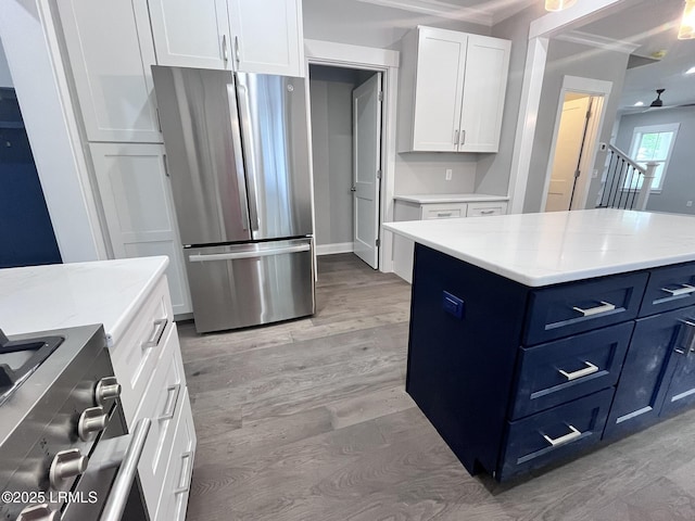 9 Attaway Ln, Beaufort, SC 29907 - kitchen with stainless steel appliances, blue cabinets, white cabinetry, light wood-style floors, and ceiling fan