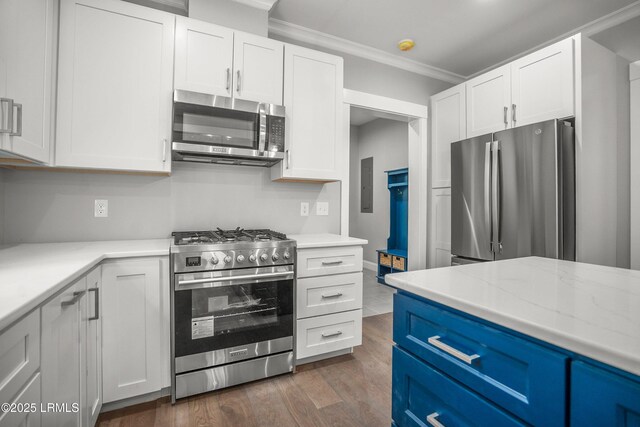 9 Attaway Ln, Beaufort, SC 29907 - kitchen featuring stainless steel appliances, crown molding, dark wood-style floors, white cabinets, and blue cabinets