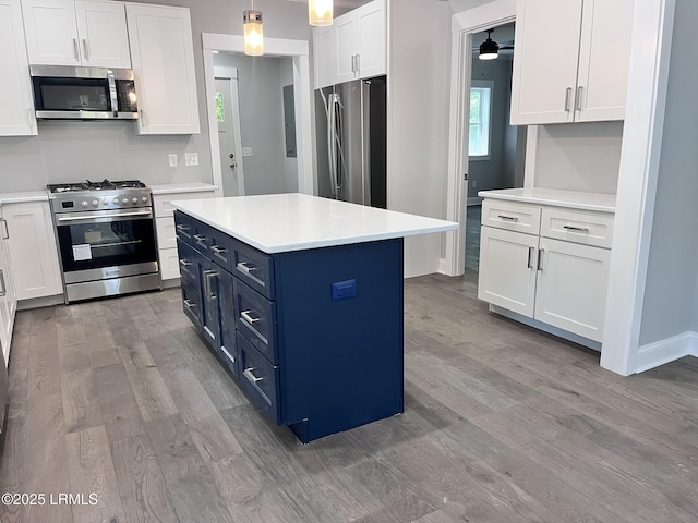 9 Attaway Ln, Beaufort, SC 29907 - kitchen featuring appliances with stainless steel finishes, blue cabinets, wood finished floors, white cabinets, and light countertops