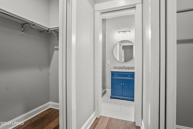 9 Attaway Ln, Beaufort, SC 29907 - bathroom featuring vanity, a spacious closet, baseboards, and wood finished floors