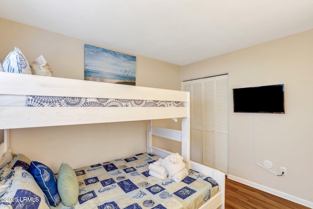 bedroom with wood-type flooring and a closet