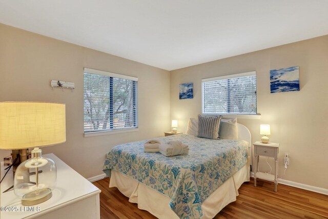 bedroom with wood-type flooring and multiple windows