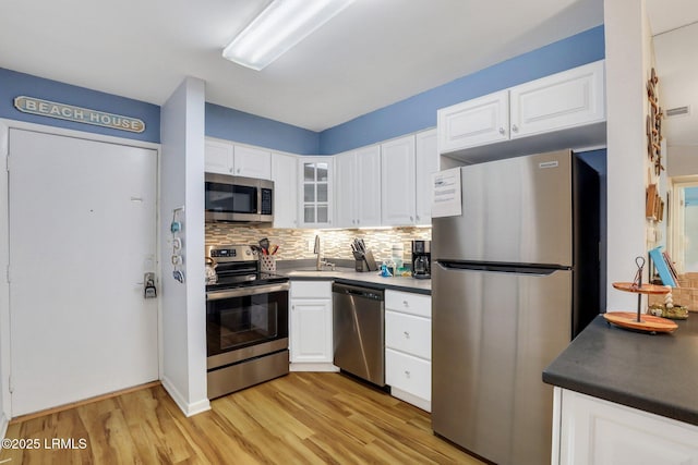 kitchen featuring appliances with stainless steel finishes, sink, white cabinets, and decorative backsplash