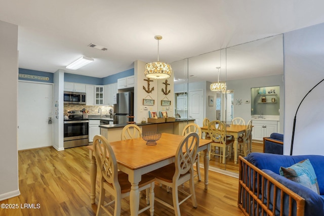 dining area featuring sink and light wood-type flooring