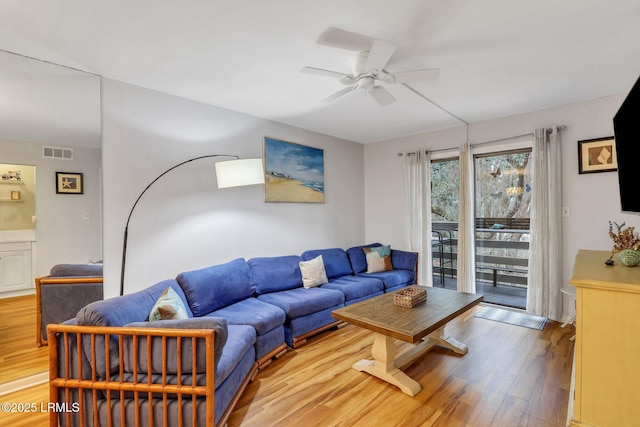 living room featuring light hardwood / wood-style floors and ceiling fan