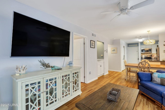 living room with ceiling fan and light wood-type flooring