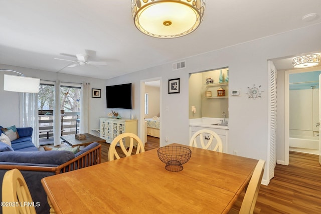 dining area featuring wood-type flooring, sink, and ceiling fan