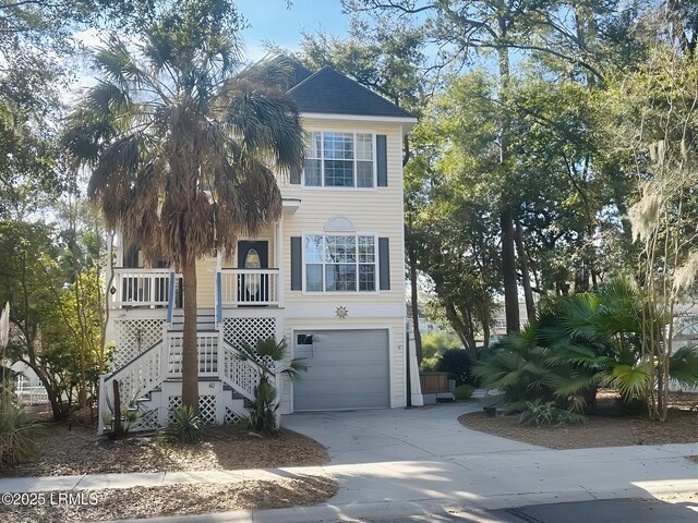 40 Victoria Square Dr, Hilton Head Island, SC 29926 - coastal home featuring covered porch, concrete driveway, stairs, and a garage