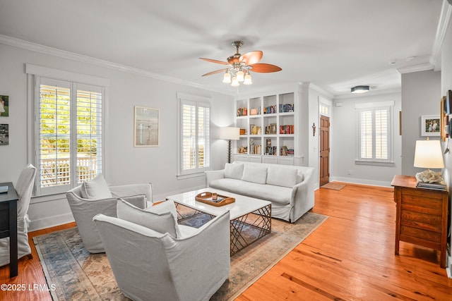 living room with a ceiling fan, ornamental molding, and light wood finished floors