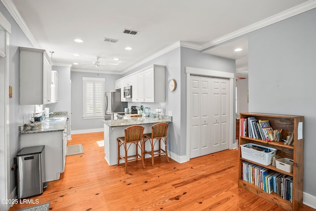 kitchen with crown molding, appliances with stainless steel finishes, and visible vents