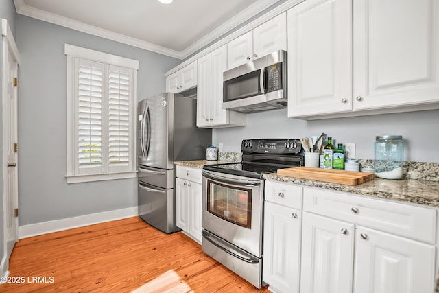 kitchen featuring ornamental molding, baseboards, white cabinets, light stone counters, and stainless steel appliances