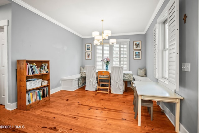 dining space with crown molding, baseboards, wood finished floors, and a chandelier