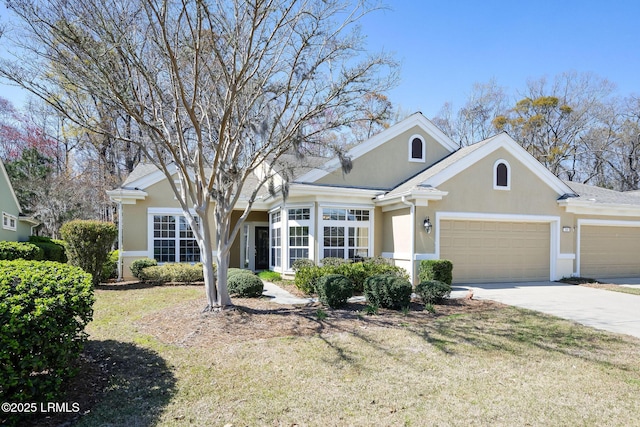 view of front of home featuring stucco siding, an attached garage, concrete driveway, and a front yard