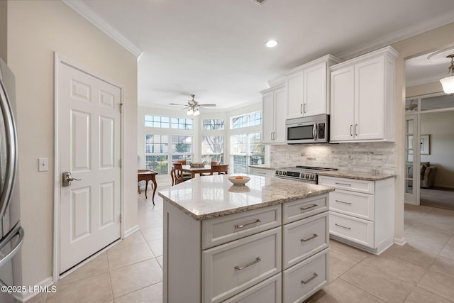 kitchen featuring crown molding, light tile patterned flooring, backsplash, and stainless steel appliances