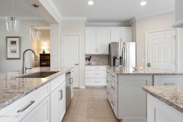 kitchen featuring ornamental molding, light tile patterned flooring, stainless steel fridge, white cabinetry, and a sink