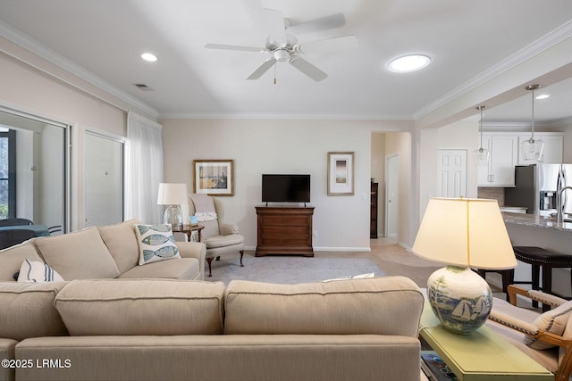 living area featuring visible vents, ornamental molding, a ceiling fan, baseboards, and light colored carpet