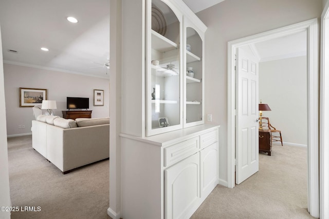 hallway with recessed lighting, light colored carpet, baseboards, and ornamental molding