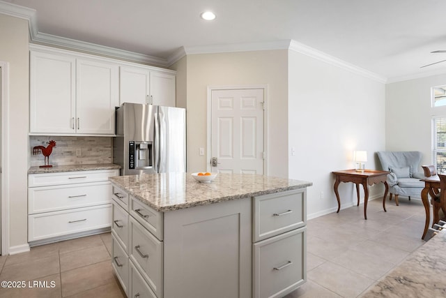 kitchen with a center island, crown molding, decorative backsplash, stainless steel refrigerator with ice dispenser, and white cabinetry