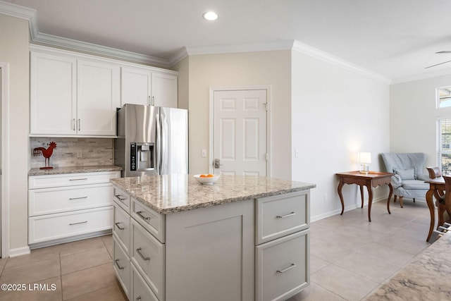 346 Landing Ln, Bluffton, SC 29909 - kitchen with white cabinets, light tile patterned flooring, stainless steel fridge, tasteful backsplash, and ornamental molding