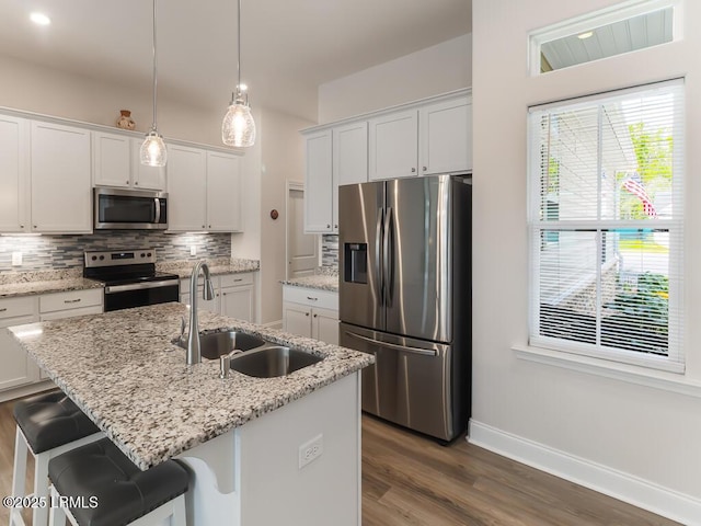 1872 Hearthstone Lake Dr, Ridgeland, SC 29936 - kitchen featuring stainless steel appliances, a sink, decorative backsplash, dark wood-style flooring, and a center island with sink