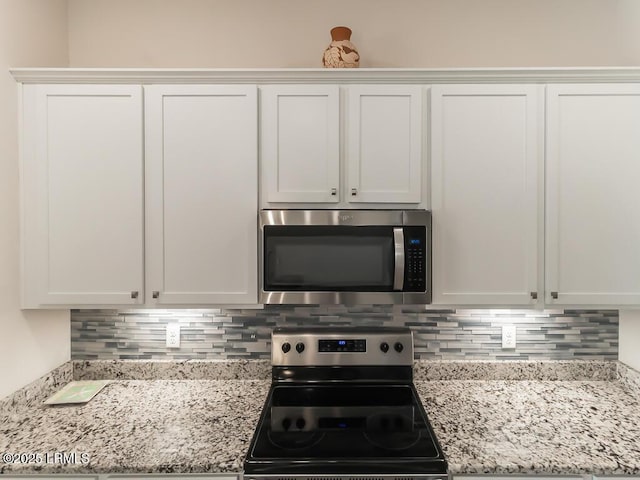 1872 Hearthstone Lake Dr, Ridgeland, SC 29936 - kitchen with stainless steel appliances, white cabinets, backsplash, and light stone counters