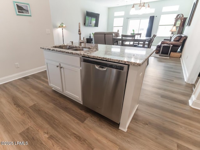 1872 Hearthstone Lake Dr, Ridgeland, SC 29936 - kitchen with stainless steel dishwasher, a sink, wood finished floors, a center island with sink, and light stone countertops