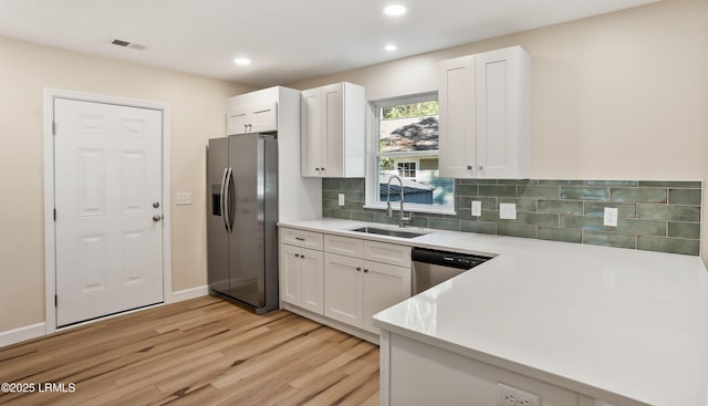 416 Meritta Ave, Beaufort, SC 29902 - kitchen featuring a sink, light countertops, light wood-style floors, white cabinetry, and stainless steel appliances