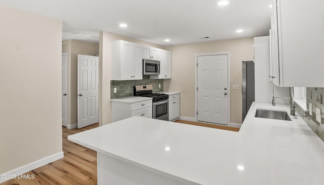 416 Meritta Ave, Beaufort, SC 29902 - kitchen with stainless steel appliances, light wood-type flooring, baseboards, and backsplash