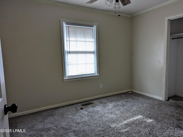 unfurnished bedroom with ceiling fan, ornamental molding, carpet floors, and a closet