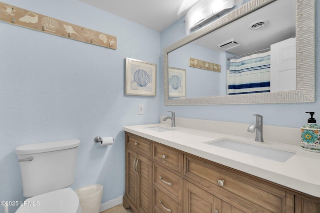 bathroom with vanity, curtained shower, and toilet