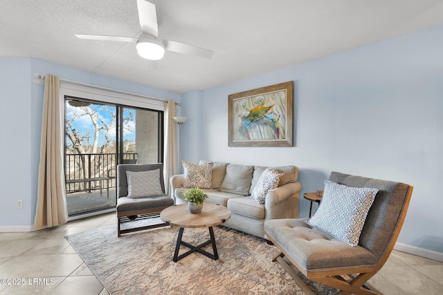 living room featuring light tile patterned flooring, ceiling fan, and a textured ceiling