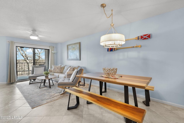 tiled dining space with ceiling fan and a textured ceiling