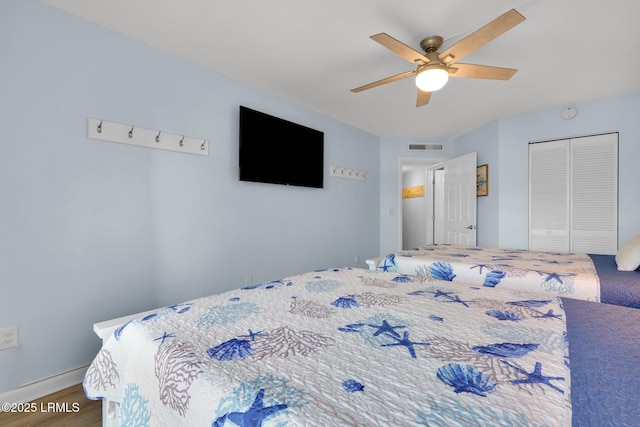 bedroom with hardwood / wood-style floors, ceiling fan, and a closet