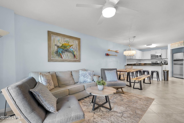 living room featuring ceiling fan, sink, and light tile patterned floors