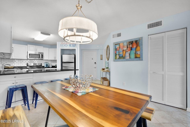 dining space with sink and light tile patterned floors