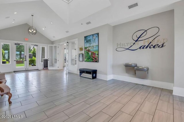 unfurnished living room featuring french doors, high vaulted ceiling, baseboards, and visible vents