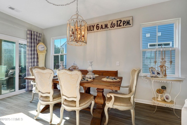 dining room featuring visible vents, baseboards, wood finished floors, and a chandelier