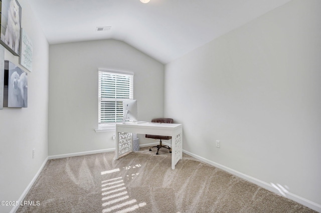 carpeted home office featuring baseboards, vaulted ceiling, and visible vents