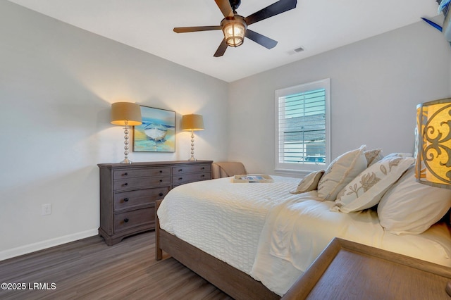 bedroom featuring wood finished floors, visible vents, baseboards, and ceiling fan
