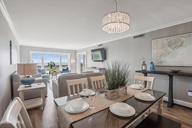 21 S Forest Beach Dr Unit 210, Hilton Head Island, SC 29928 - dining space featuring crown molding, wood finished floors, and a chandelier