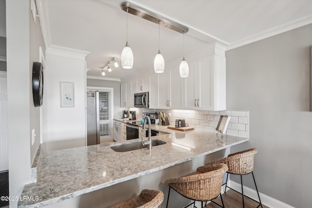 21 S Forest Beach Dr Unit 210, Hilton Head Island, SC 29928 - kitchen with appliances with stainless steel finishes, ornamental molding, tasteful backsplash, white cabinets, and light stone counters